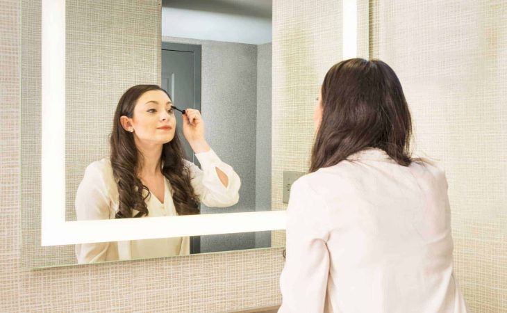 Woman Putting on Makeup in Front of Seura Allegro Lighted Mirror